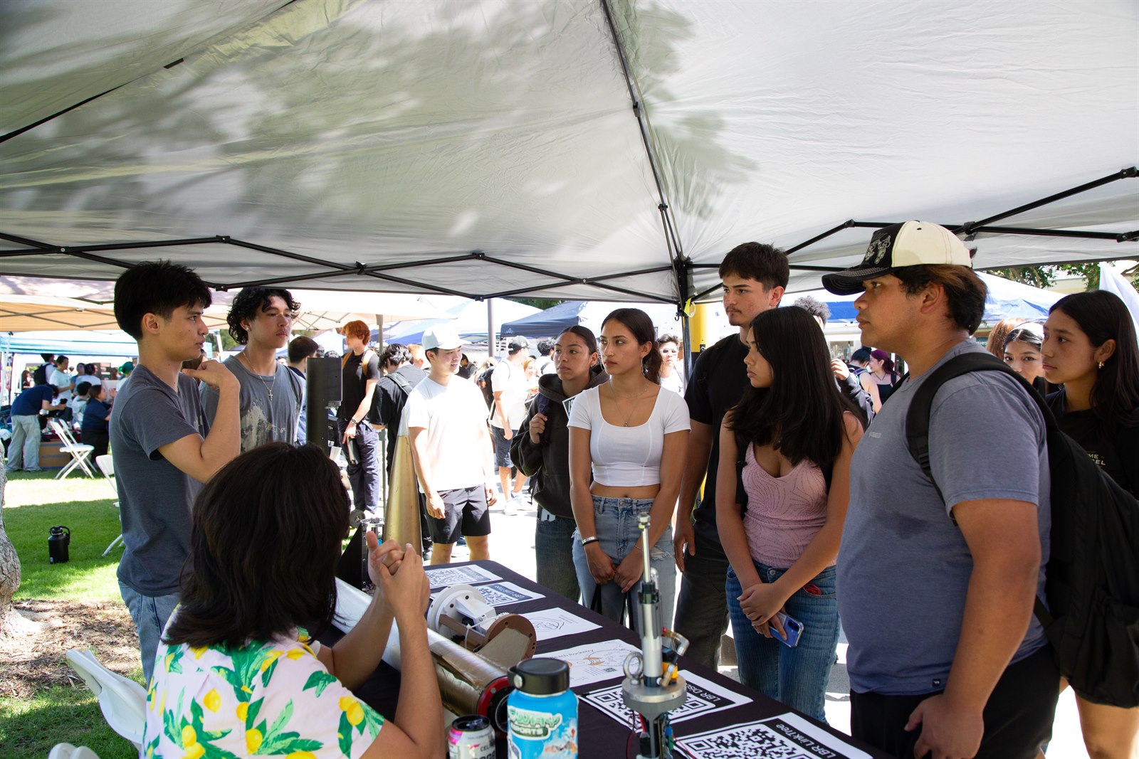 Long Beach Rocketry members speaking with students at a campus outreach booth
